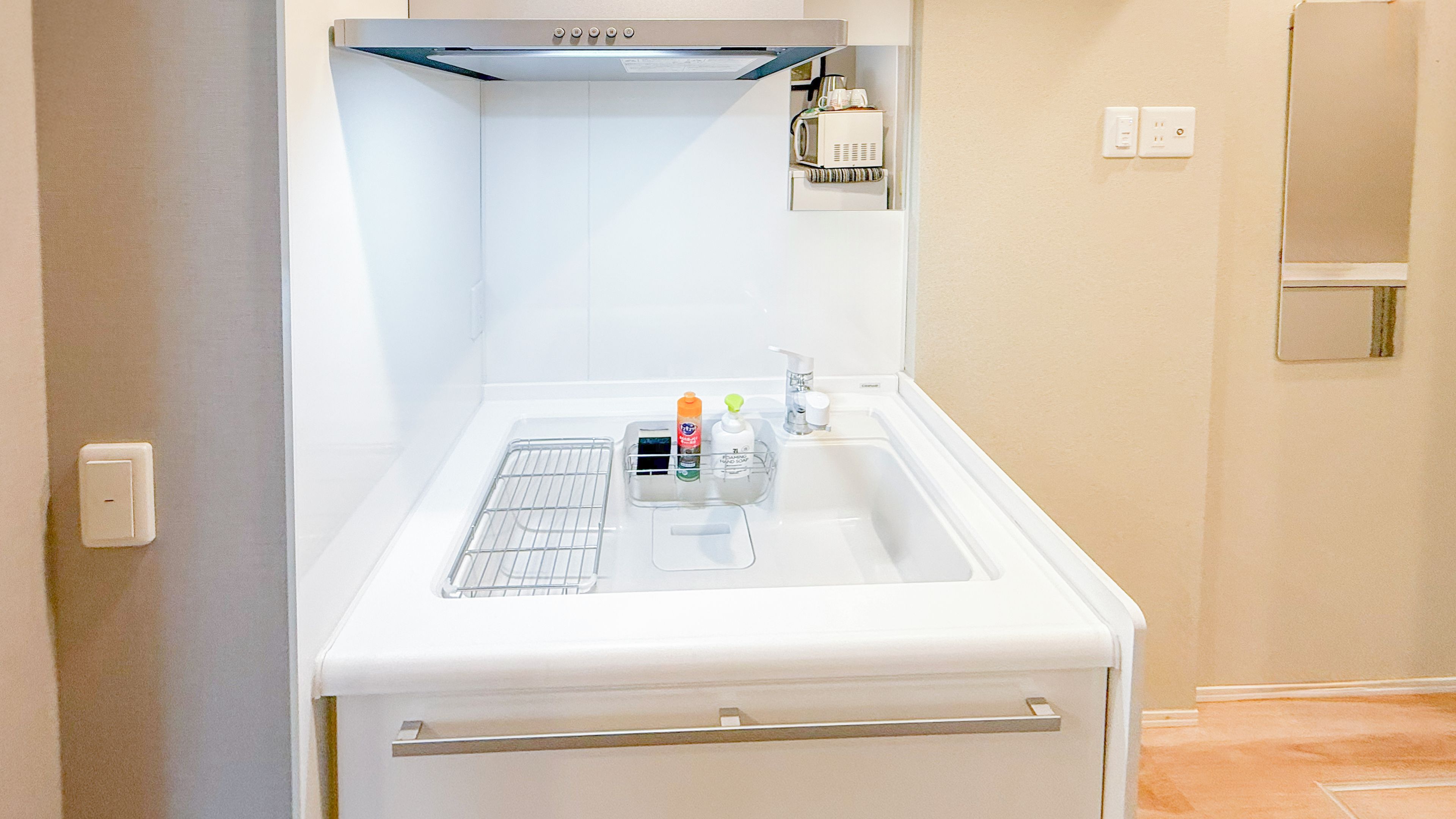 A compact kitchen with a built-in refrigerator, a sink, and a small countertop.