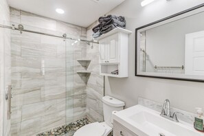 Regadera, secadora de cabello, toallas, papel de baño 