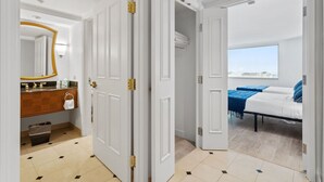 Hotellihuone, jossa on kylpyhuone, sänky ja näkymä kaupunkiin.