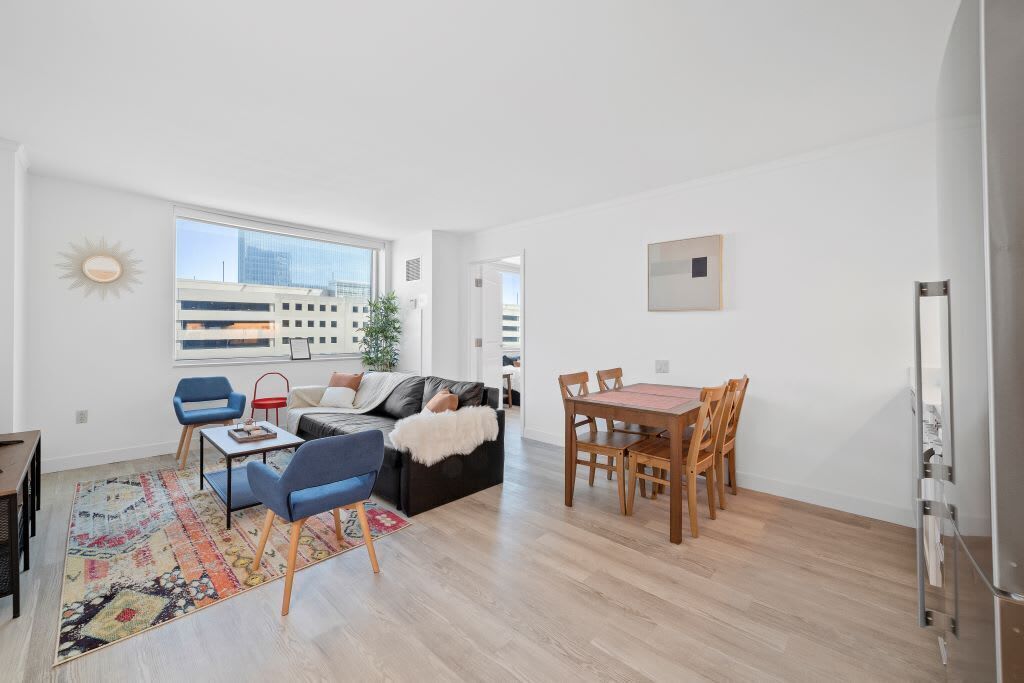 A modern living space with a dining area, a sofa, and a coffee table.