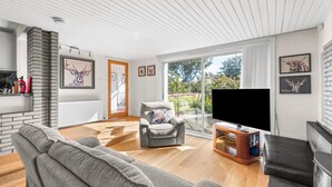 A modern living room with a fireplace, a television, and a sofa. - The Albatross - 3 bed Carnoustie Classic (Angus)