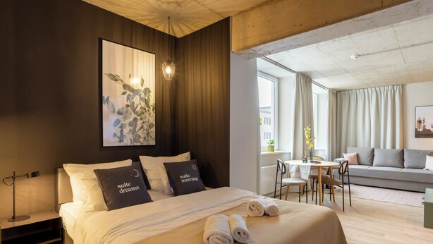 Een moderne hotelkamer met een groot bed, een bureau en een bank.