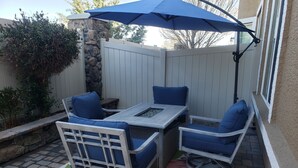 A patio with a table and chairs, a blue umbrella, and a decorative rug. - Beautiful Townhouse close to Lake Tahoe (Reno)