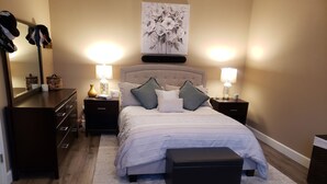 A bedroom with a large bed, two bedside tables, a dresser, a mirror, and a painting on the wall. - Beautiful Townhouse close to Lake Tahoe (Reno)