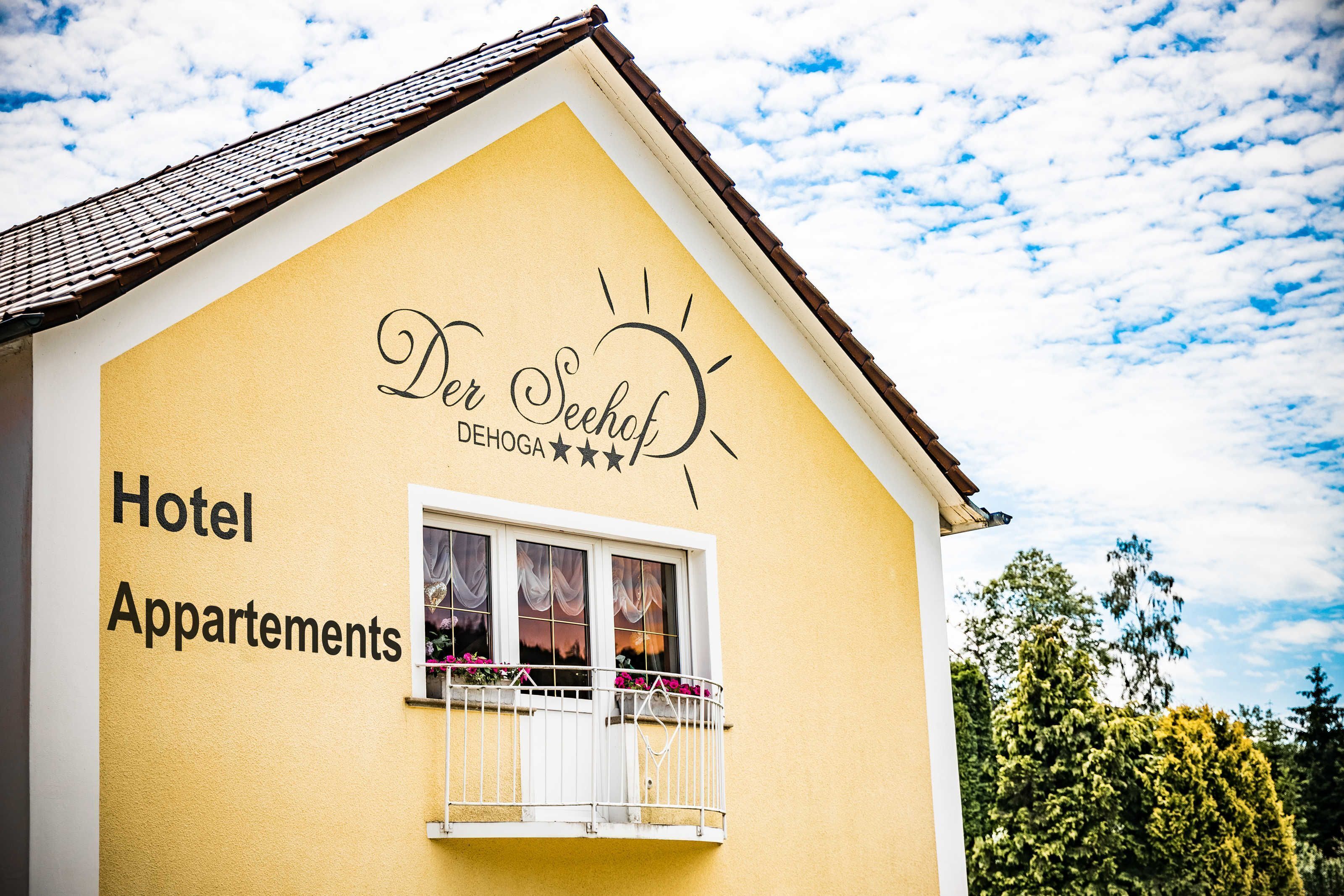 Un bâtiment jaune sur lequel on peut lire l’inscription « Der Seefhof DEHOGA » et « Hôtel avec appartements ».