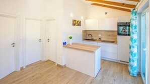 A modern kitchen with white cabinets, a wooden countertop, and a built-in oven. - House Villa Verdi (Tkon)