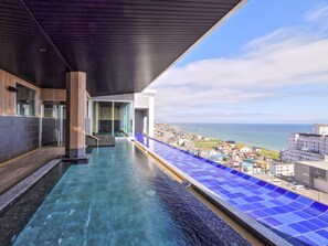 A modern infinity pool with a clear view of the sea and a cityscape in the background. - Hakodate Yunokawa Onsen Umi to Akari / Hewitt Resort (Hakodate)