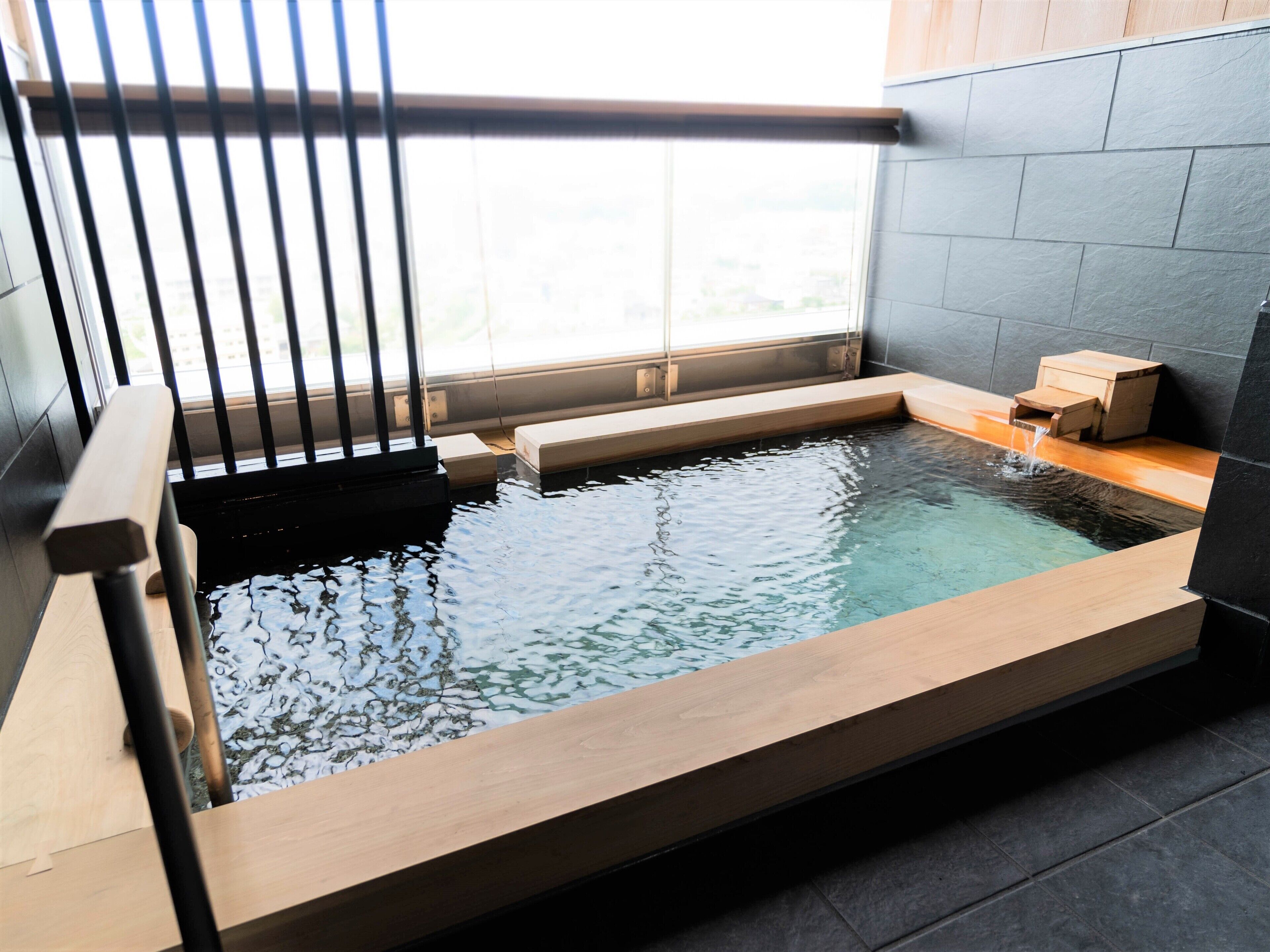 Un spa moderne doté d’une terrasse en bois et d’une petite piscine.