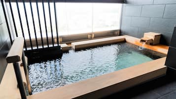 Un spa moderne doté d’une terrasse en bois et d’une petite piscine.
