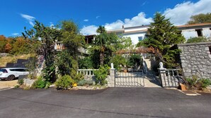 A large, two-story building with a stone facade and a gated entrance. - Apartment Klara (Dramalj)