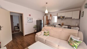 Ein modernes Apartment mit Wohnzimmer, Küchenzeile und Essbereich.