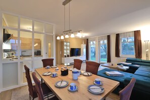 A modern living room with a dining area, a sofa, and a TV. - Seebach Whg. S01, Deutschland (Ostseebad Boltenhagen)