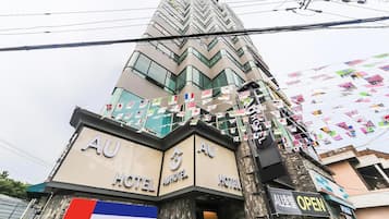 A hotel with multiple signs reading "AU HOTEL" and a flag of France displayed.