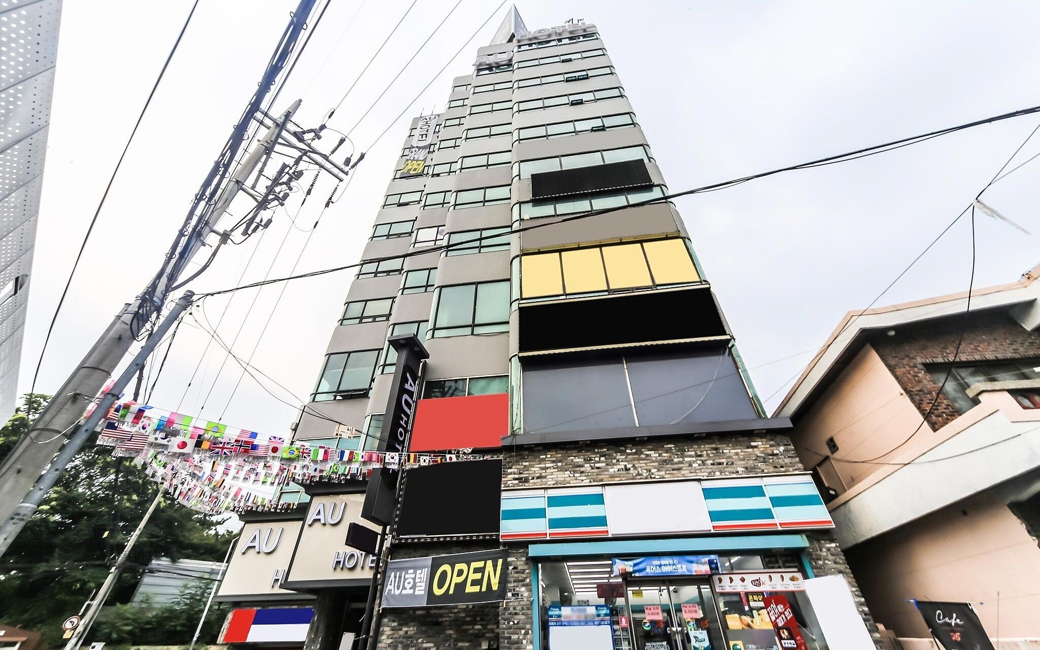 A hotel with multiple floors, a prominent 'OPEN' sign, and a variety of flags.