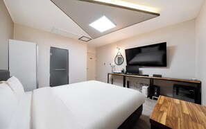 A hotel room with a bed, a desk with a flat-screen TV, a mirror, and a wardrobe. - Gwangju Chungjangro Gold Brown Hotel (Gwangju)