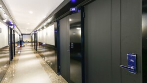 A modern hotel corridor with a polished floor, dark walls, and a sign indicating room number 302. - Cheonan E (Cheonan)
