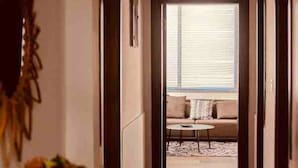 A hallway leading to a living area with a sofa and a coffee table.