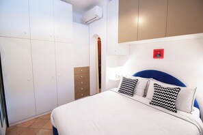 A bedroom with a bed, a wardrobe, a dresser, and a wall-mounted air conditioner. - La Scalinatella - Private apartment with Sea View (Forio)