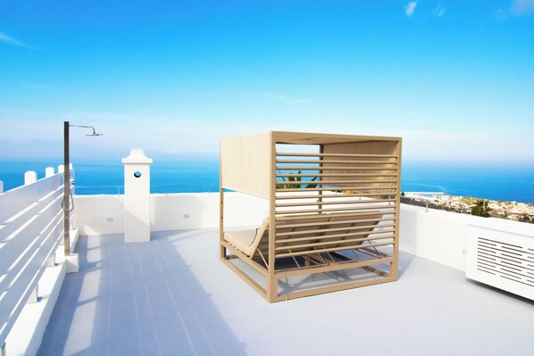 A sunlit terrace with a wooden pergola and a white chair, overlooking a coastal view. - La Scalinatella - Private apartment with Sea View (Forio)
