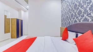 Un dormitorio moderno con una cama, un armario y una pared estampada.