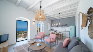 Una sala moderna con un sofá, sillas, un televisor y un comedor.