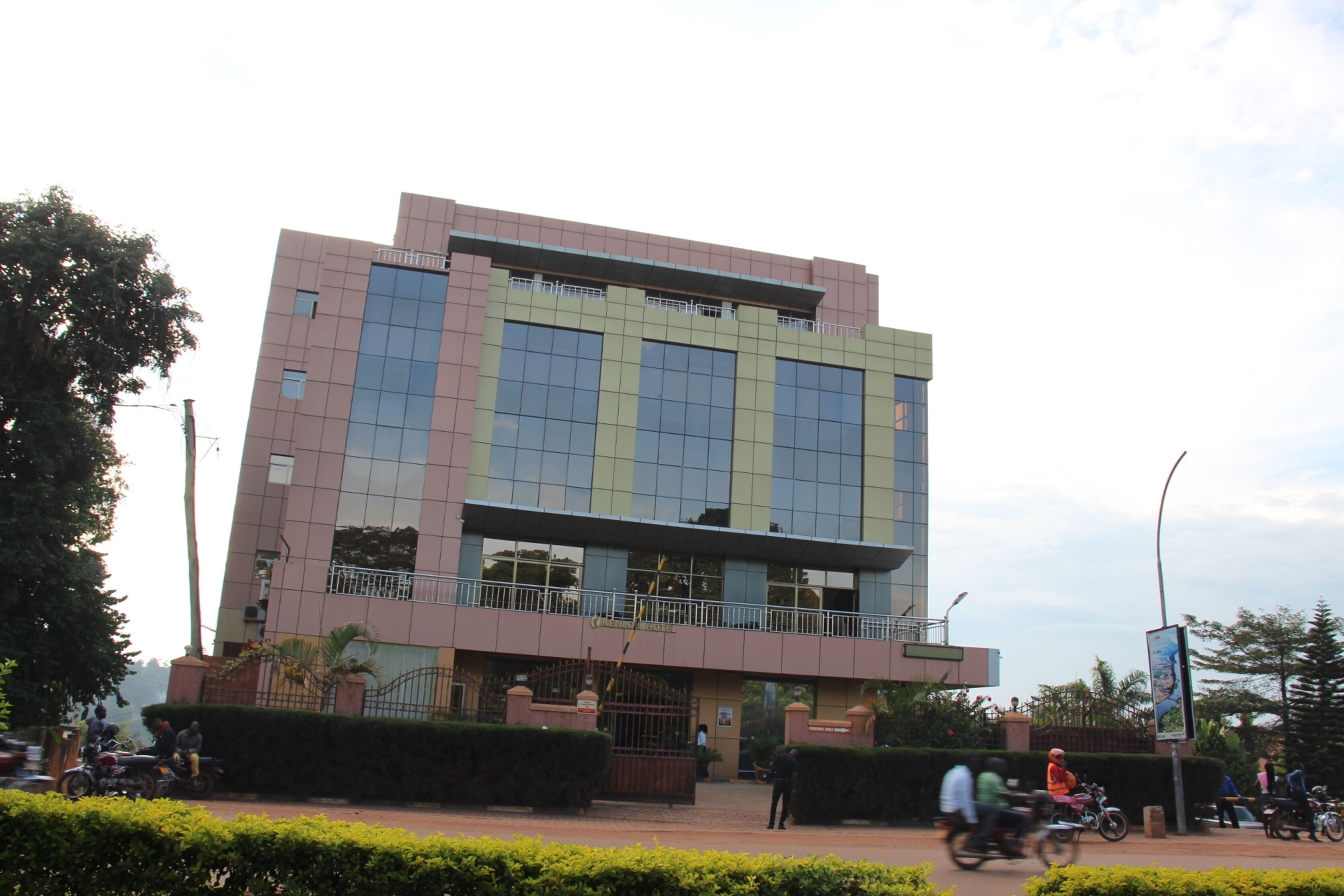 A modern building with a flat roof, large windows, and a balcony.