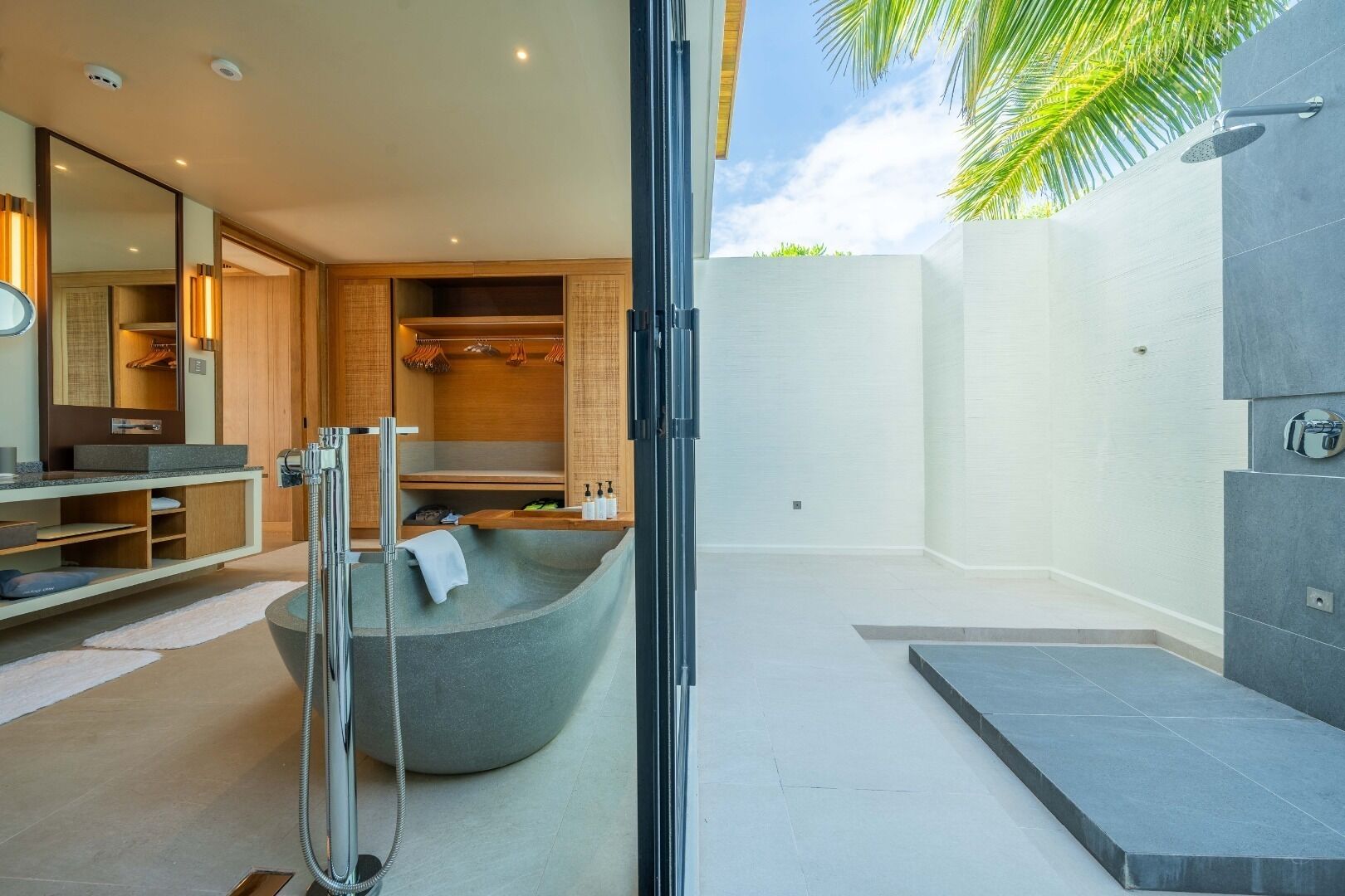 Un baño moderno con una bañera grande, una ducha a pie y un área de ducha con mampara de vidrio.