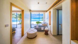 Une salle de bain moderne avec une baignoire, un coin salon et une vue sur la plage.