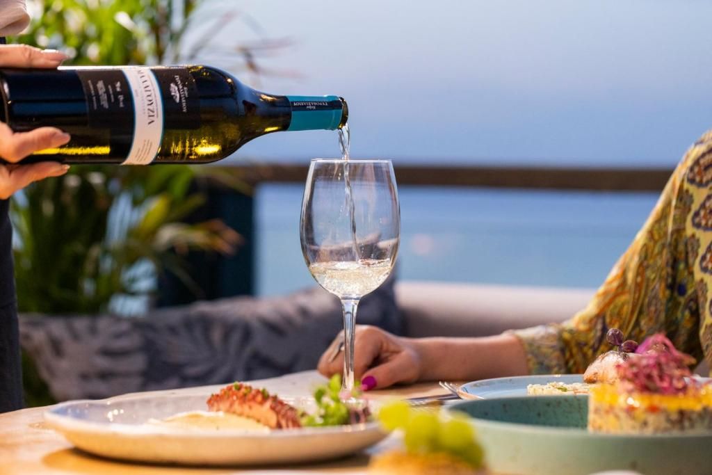 A person pouring wine into a glass.