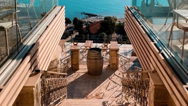 Un balcón con barandilla de vidrio que ofrece vistas al mar.