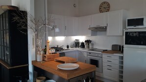 A modern kitchen with white cabinets, a wooden countertop, a coffee maker, and a microwave. - Spacious 2 bed Appartment full air con, Sun terrace,stunning views, Pools (Fitou)