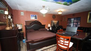 Un dormitorio con cama, escritorio, silla y ventilador de techo.