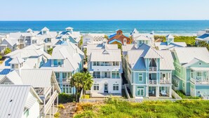 Een kustwoongebied met huizen met meerdere verdiepingen en balkons, met uitzicht op de oceaan.