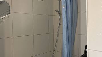Un baño con ducha, inodoro y lavamanos.