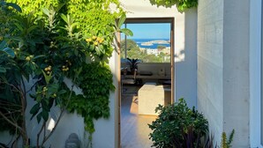 Una casa moderna con vista al mar a través de un ventanal de vidrio.