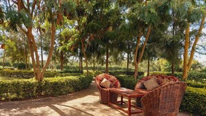 A patio area with wicker furniture and stone flooring. - Athi Holiday Resort (Athi River)