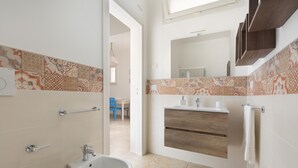 Un bagno moderno con un bidet, un lavandino e uno specchio.