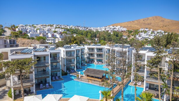 A hotel with multiple swimming pools, balconies, and a view of a hillside town. - Ladonia Hotels Mio Bianco  (Bodrum)