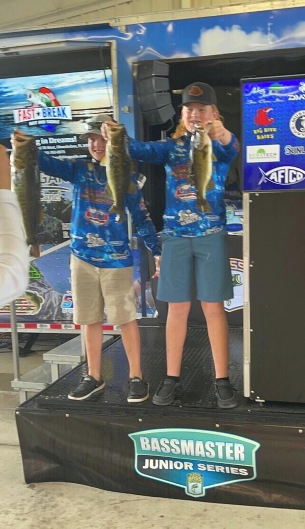 Two individuals on a stage holding fish, with a banner reading "Bassmaster Junior Series" at the bottom. - Redneck Riviera ,fishing relaxing paradise   On canal , very close to locks (Buckhead Ridge)