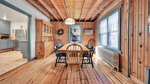 Un intérieur en bois comprenant une table à manger, des chaises et un lustre.