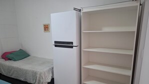 A bedroom with a bed, a wardrobe, and a small table. - Studio BeiraMar-Praia Grande, Aviação-Free 500MB WiFi  (Praia Grande)