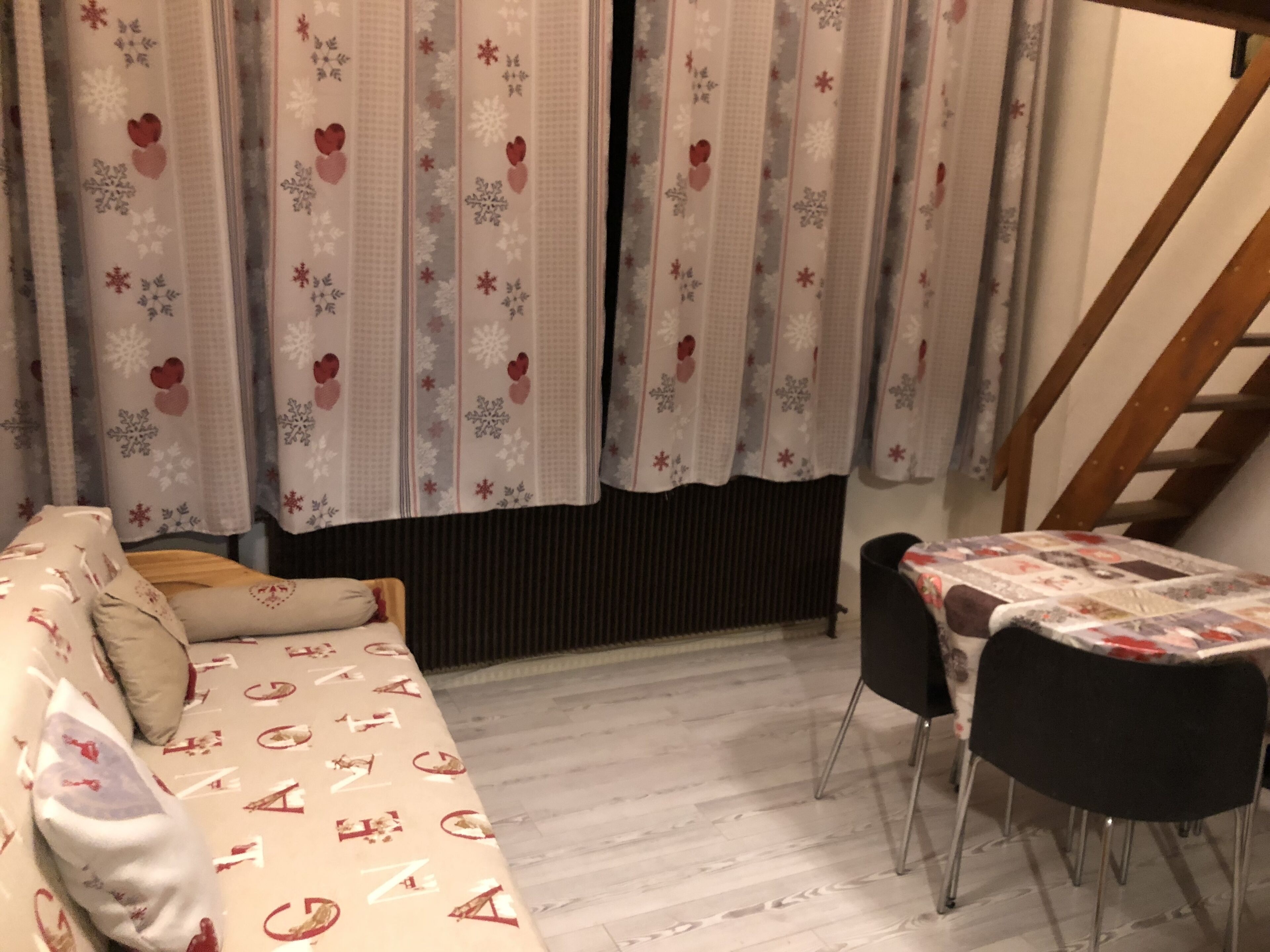 Una stanza accogliente con un divano e un tavolo da pranzo con sedie.