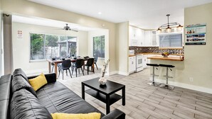 A modern apartment with a living room, dining area, and kitchen.