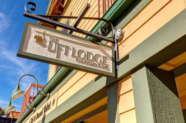 Un cartel que indica 'The Loftage Condominium', con un emblema decorativo y un farol cercano.