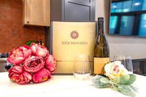 Una botella de vino de Portlandia, un ramo de flores y una caja con el rótulo 'KBM RESORTS' y un logo.