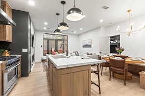 Una cucina moderna con isola centrale, mobili in legno ed elettrodomestici in acciaio inossidabile.