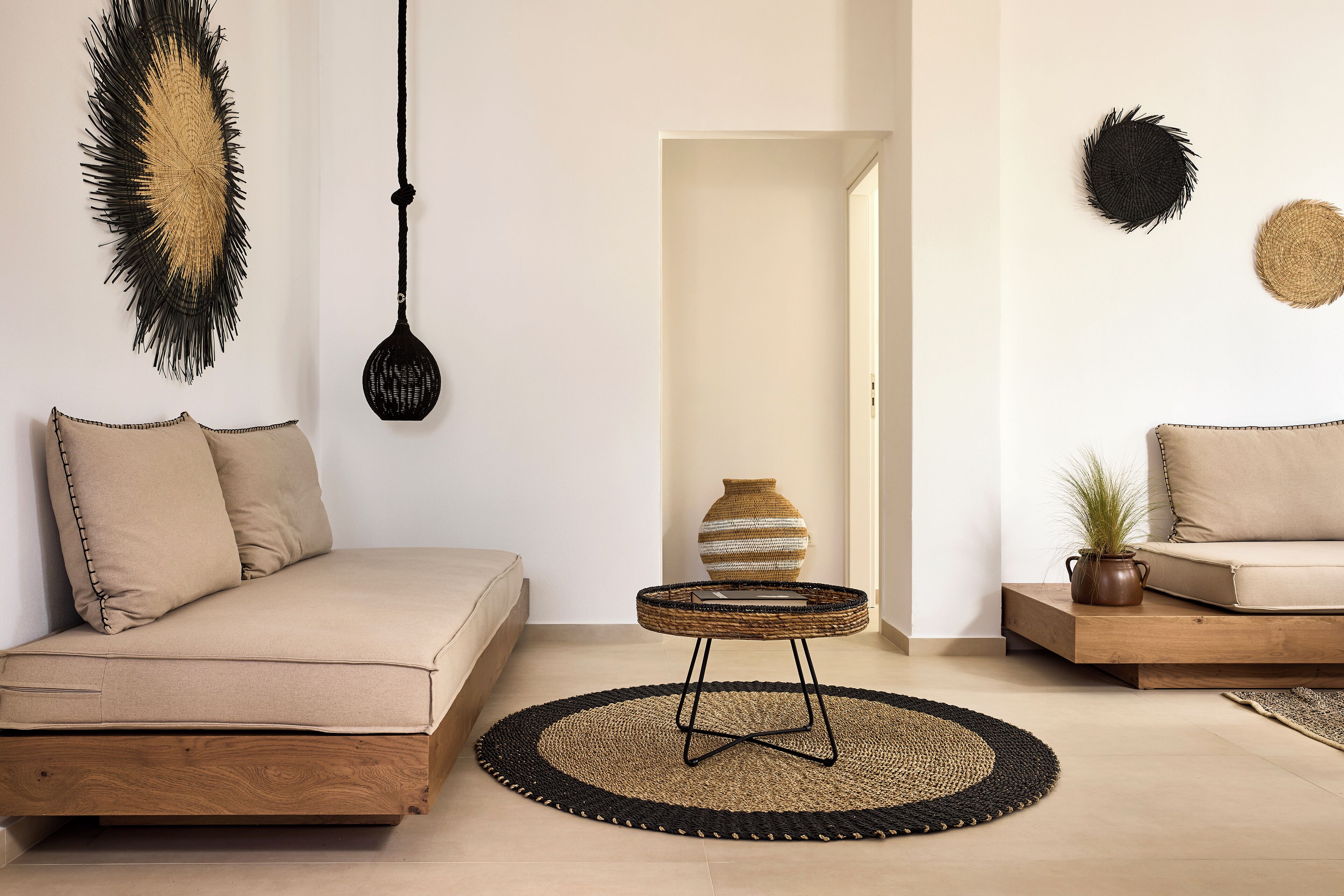 Ein minimalistisches Wohnzimmer mit einer Couch, einem kleinen runden Tisch und einem Teppich.