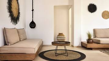 Ein minimalistisches Wohnzimmer mit einer Couch, einem kleinen runden Tisch und einem Teppich.