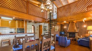 A spacious living area with a wooden staircase, a fireplace, and a dining area with wooden furniture. - Cal Cristo, Villa with private pool in a quiet area (Pollensa)