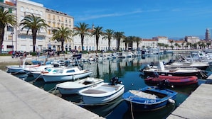 A marina with various boats docked, surrounded by buildings and palm trees. - Luxury apt With Roofed Patio Near Beach & Center (Split)